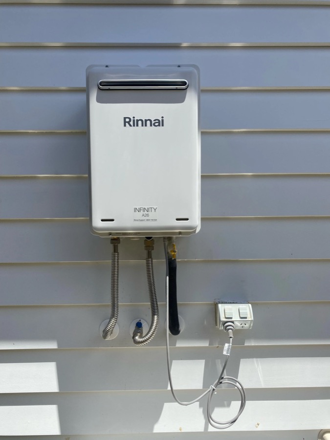 Rinnai Infinity gas hot water unit installed on an exterior wall by Fernz Gas & Plumbing Specialist